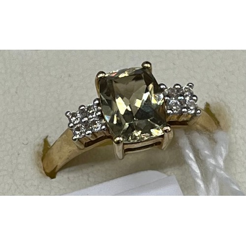 41 - 10ct yellow gold ladies ring set with a pale green topaz stone off set by white spinel stone shoulde... 