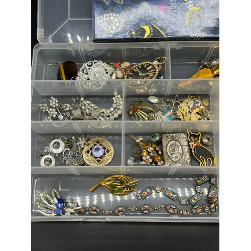 49 - A Plastic box containing a quantity of costume jewellery to include brooches, Millefiori bracelets, ... 