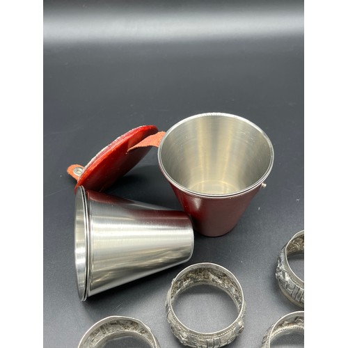 64 - A Set of six Indian silver napkin rings. Together with a Danish drinking cup set with leather pouch.