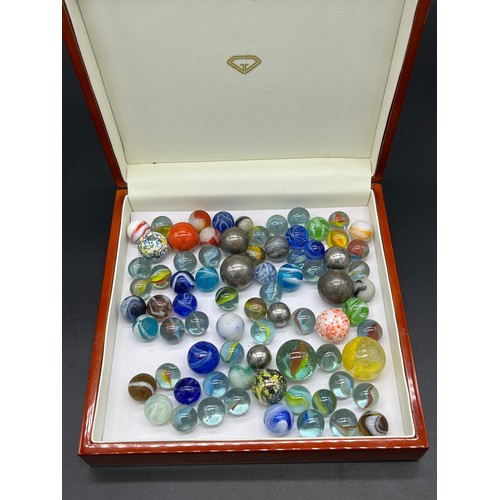 75 - A Quantity of antique and vintage marbles includes two witches eye marbles, various cat eyes and met... 