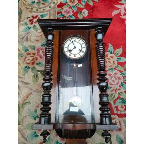 244 - Antique Vienna wall clock with pendulum and key. In a working condition.