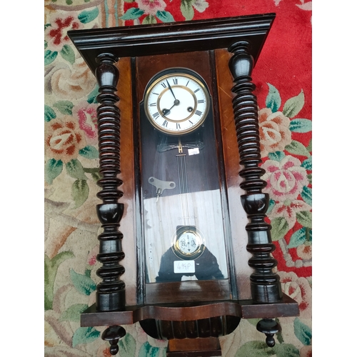 244 - Antique Vienna wall clock with pendulum and key. In a working condition.