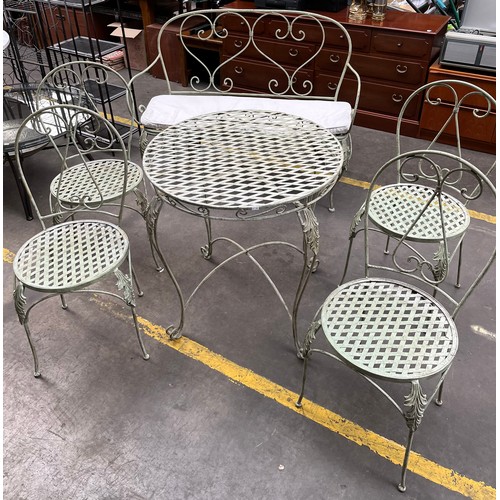 251 - Wrought Iron garden table, four chairs and matching two seat bench