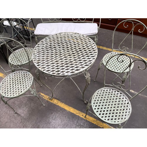 251 - Wrought Iron garden table, four chairs and matching two seat bench