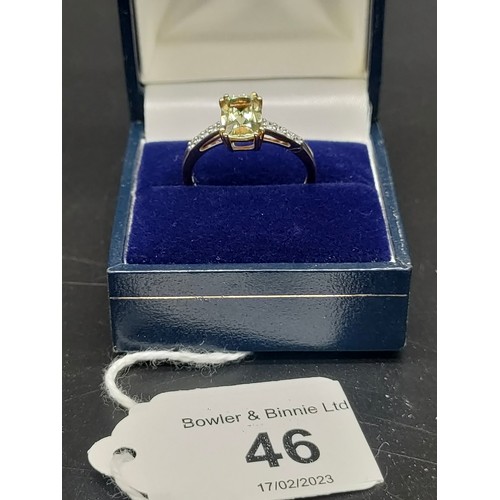 46 - 10ct yellow gold ladies ring set with a large green topaz stone off set by White spinel stone should... 