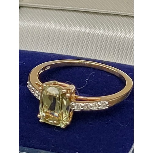 46 - 10ct yellow gold ladies ring set with a large green topaz stone off set by White spinel stone should... 