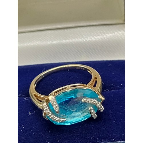 36 - 9ct yellow gold ladies ring set with a large blue topaz stone set with 0.07cts of diamonds. [Ring si... 