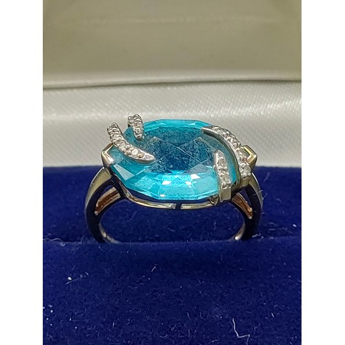 36 - 9ct yellow gold ladies ring set with a large blue topaz stone set with 0.07cts of diamonds. [Ring si... 