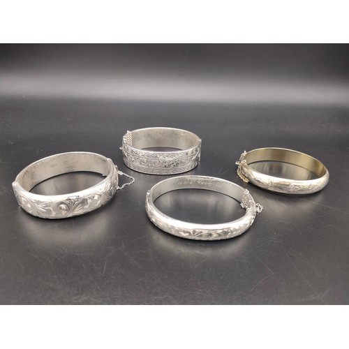 48 - A Lot of four thick 925 silver bangles. All designed with engraved panels.