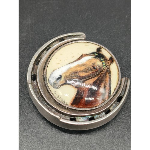 8 - A Sterling silver and enamel painted horse shoe brooch/ pendant. Silver horse shoe having a porcelai... 