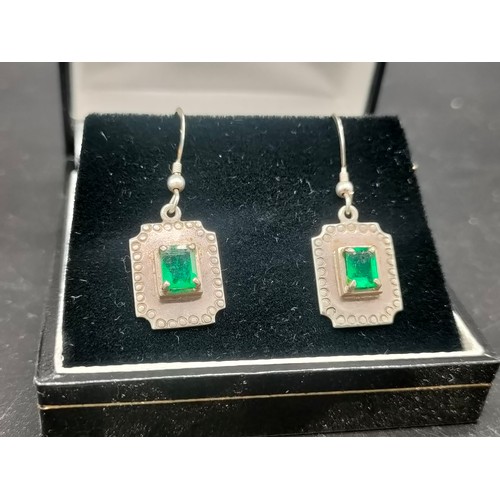 9 - A Pair of silver earrings set with Emerald stones.