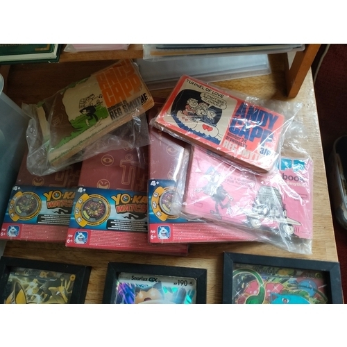 254 - Box of Andy capp books , Pokémon 2 framed large cards along with new yokai watch folders