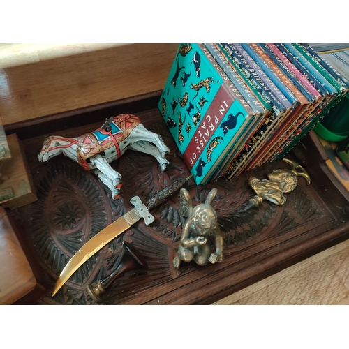 265 - Carved eastern tray containing tinplate toy horse with key , treen items , Muller child's books etc