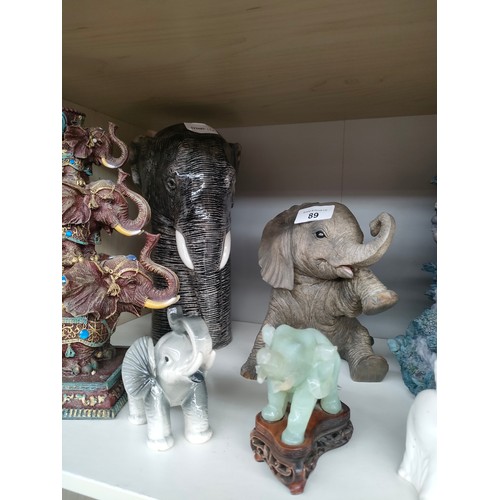 89 - A Shelf of Elephant figures includes Quail porcelain elephant head, Chinese Jade coloured elephant e... 