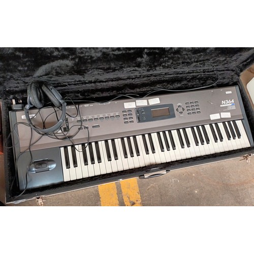 445Y - Korg keyboard in a hard back case long with speaker and headphones