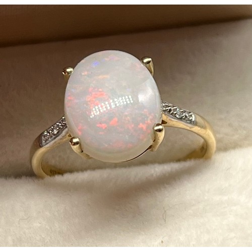 36 - 10ct yellow gold ladies ring set with a large single opal off set by diamond shoulders. [Ring size R... 