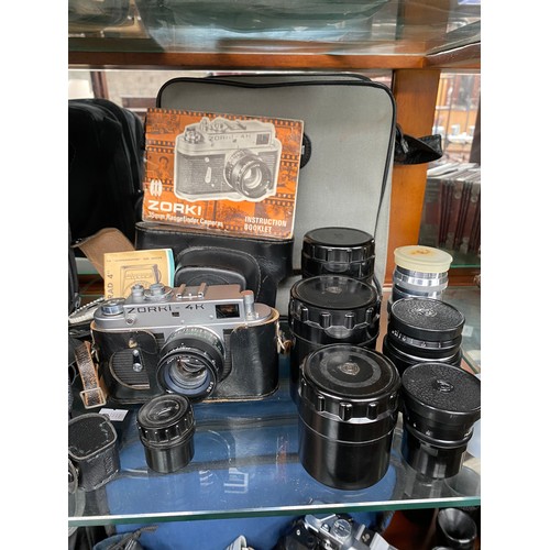 191 - A Shelf of camera items to include Minolta X-300 Camera, Zorki- 4k camera and various lenses.