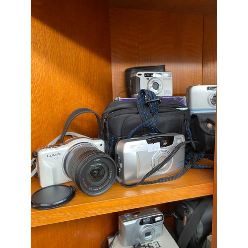 199 - Three shelves of various cameras includes Canon t50, Canon EOS 300, Rebel X, XL Zoom and many others... 