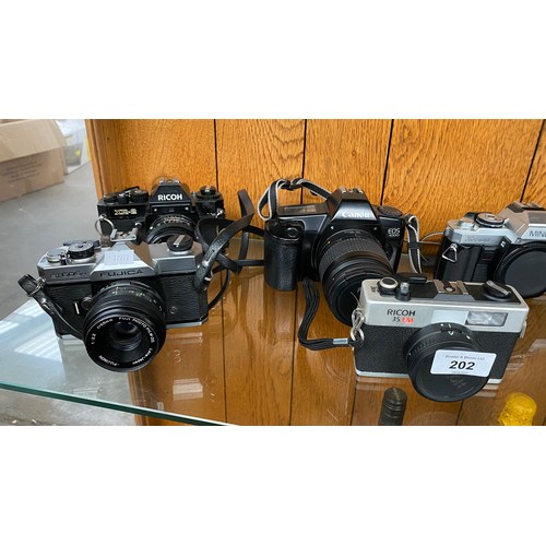 202 - A Shelf of cameras to include Ricoh XR-2, Fujica ST605N, Canon EOS 1000, Minolta X-500, Ricoh and Pr... 