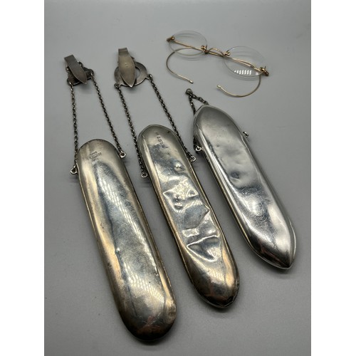 32 - Three Birmingham silver spectacle holders. Together with gilt metal spectacles.