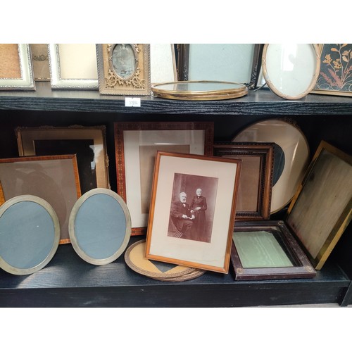 430 - Two shelves of antique photo frames of various sizes.