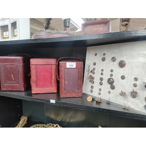 438 - Shelf of 19th century brass carriage clock cases and two sleeves of military antique uniform buttons... 