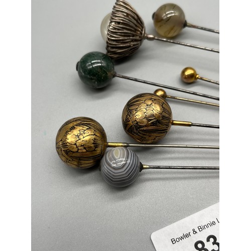 83 - A Collection of antique hat pins. Includes agate sphere hat pins, gold worked and silver coloured ha... 