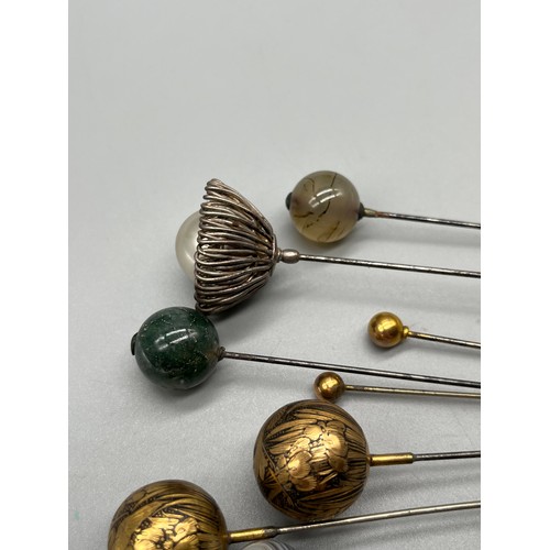 83 - A Collection of antique hat pins. Includes agate sphere hat pins, gold worked and silver coloured ha... 