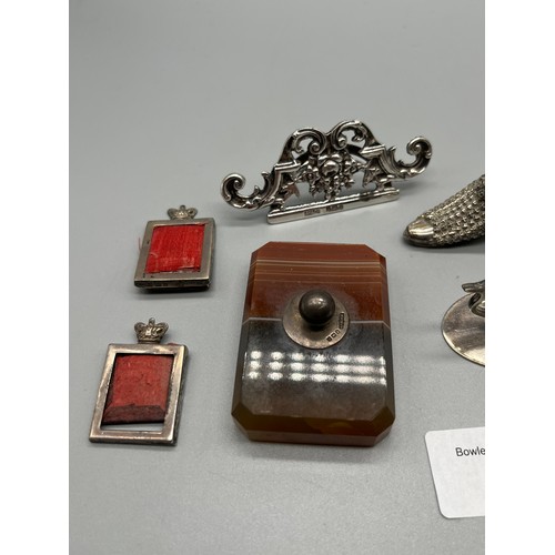 77 - A Collection of silver marked items to include agate paperweight, duck shaped card holders, pin cush... 