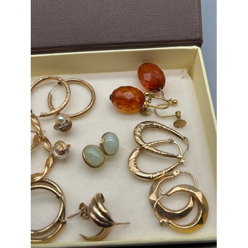 65 - Nine pairs of 9ct gold earrings. Includes 9ct and amber drop earrings, 9ct and jade earrings and var... 