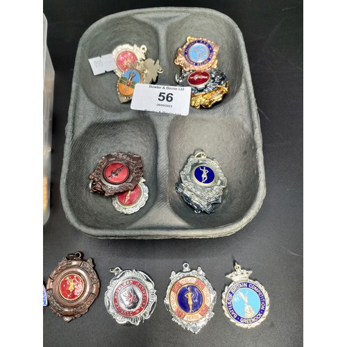 56 - Two trays of collectable Scottish dance badges and medals.