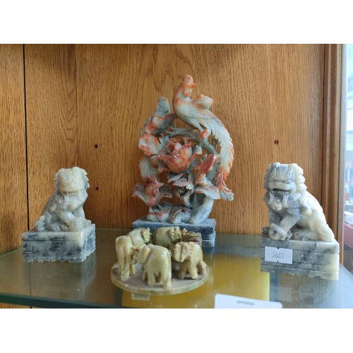 84 - A Shelf of oriental soapstone figures including foo dogs, elephants and birds