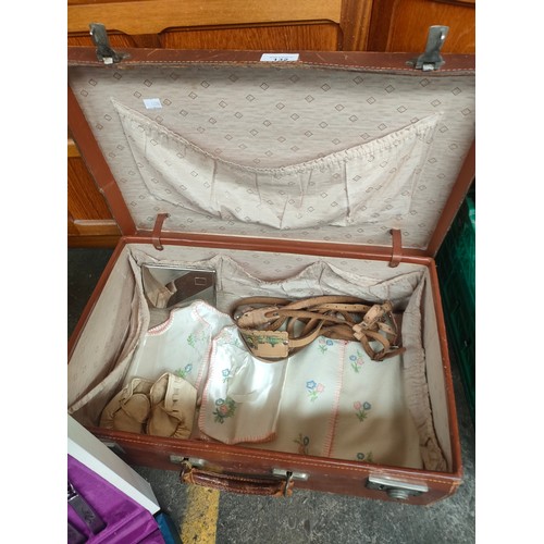 132 - Vintage suitcase containing canteen of cutlery and vintage babies shoes and waistcoats along with si... 