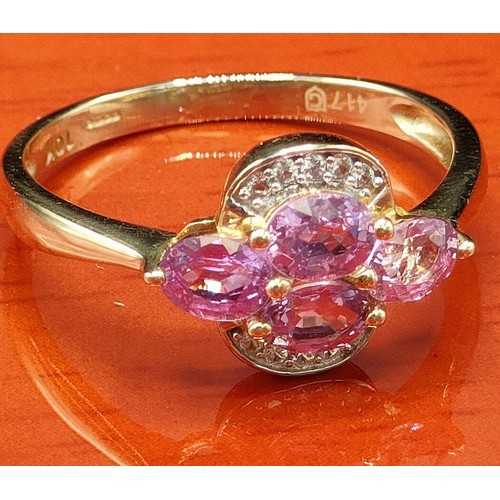 38 - 10ct yellow gold ring set with four purple topaz stones surrounded by white spinel stones. [Ring siz... 