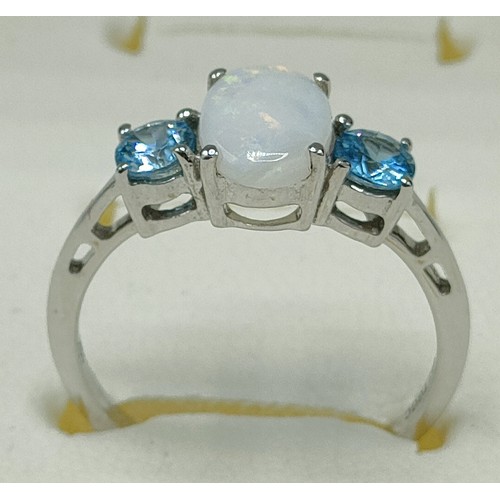 41 - 10ct white gold ring set with an oval cut opal stone off set by blue topaz stones to each shoulder. ... 