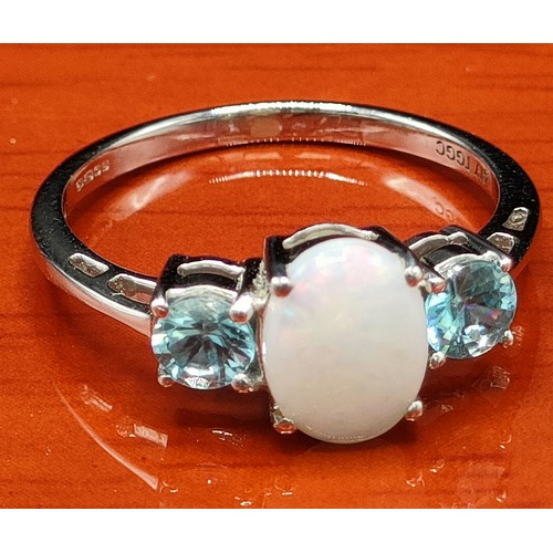 41 - 10ct white gold ring set with an oval cut opal stone off set by blue topaz stones to each shoulder. ... 