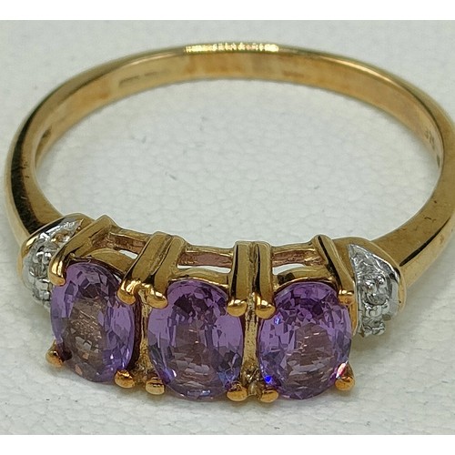 42 - 9ct yellow gold ring set with three purple topaz stones off set by diamond shoulders. [Ring size Q] ... 