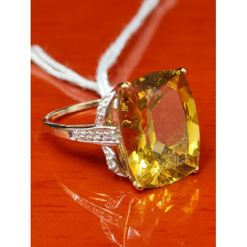 28 - 10ct yellow gold ring set with a large yellow stone off set by white spinel stones. [Ring size R 1/2... 