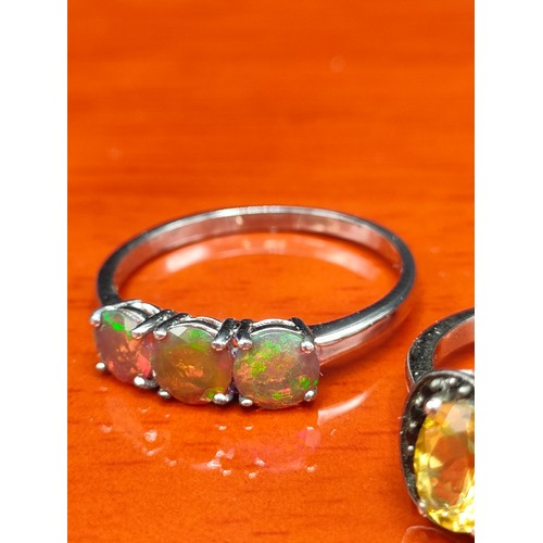 12 - Four 925 silver and gem stone rings includes three opalescent orange stone set ring.