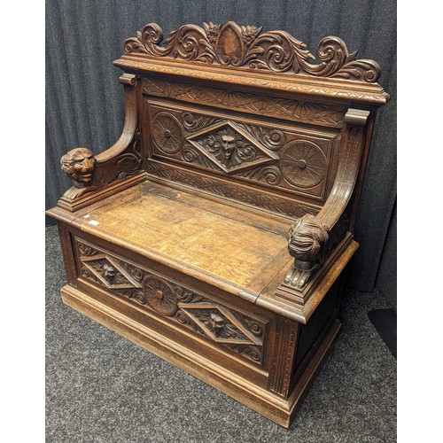 912 - Victorian oak monks bench, carved foliate design to the top above a carved mask to the centre and li... 