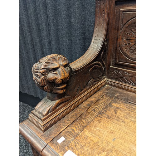 912 - Victorian oak monks bench, carved foliate design to the top above a carved mask to the centre and li... 