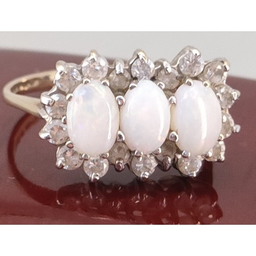 742 - 9ct yellow gold ladies ring set with three opal stones surrounded by white spinel stones. [Ring size... 