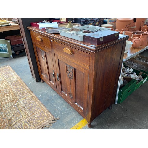 264 - Early 20th century stained oak sideboard; Art Nouveau Inspired carved panels, comes with key.