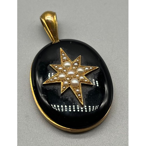 708 - Victorian Gold mourning pendant; set with a large black stone with a centre star fitted with pearls.... 