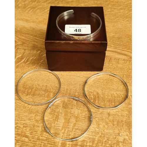 48 - Four various silver bangles; 2000 millennium London silver bangle and three various other silver ban... 