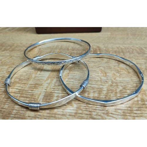 48 - Four various silver bangles; 2000 millennium London silver bangle and three various other silver ban... 