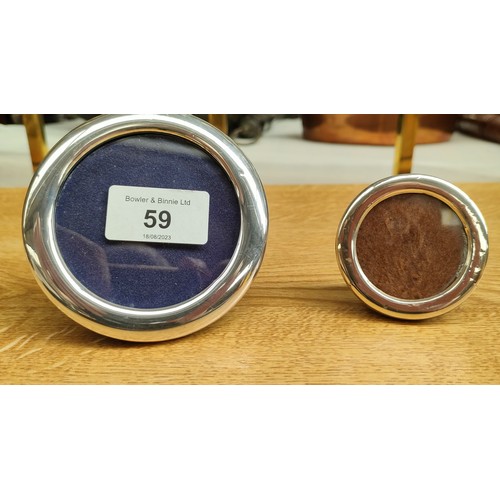 59 - Two small silver round photo frames. [largest 9.5cm diameter]