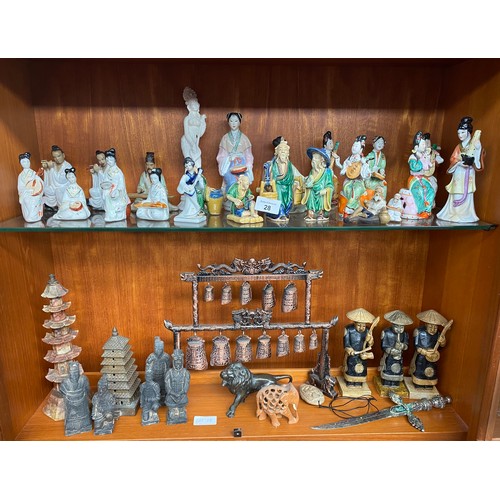 28 - Two shelves of oriental porcelain and wooden carved figures to include terracotta style figures and ... 