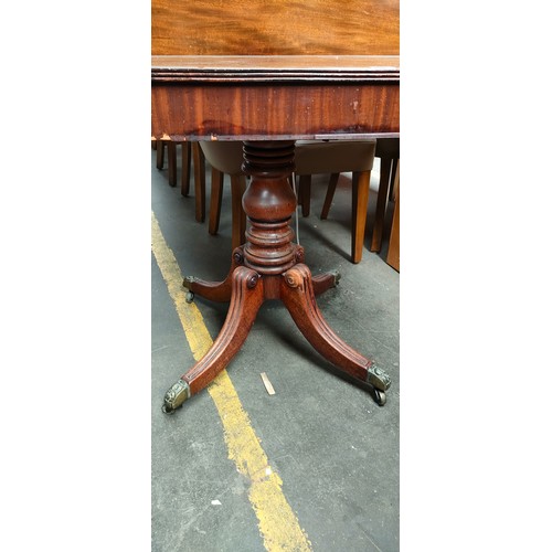 263 - 19th century mahogany games table, the flop top above a baluster column raised on four scroll out sw... 