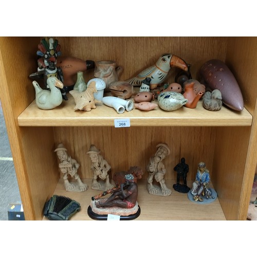 268 - Two shelves of collectable odds to include; clay items and wooden carved figurines, Various terracot... 